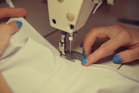 Close-up of working sewing machine. Sewing machine foot on material with threaded needle ready to sew.の写真素材