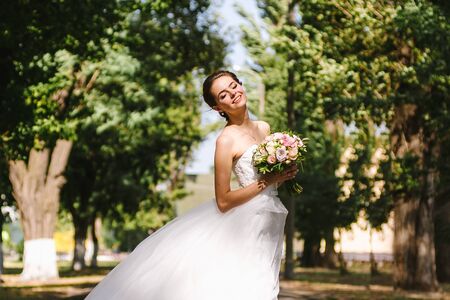 Beautiful brunette bride portrait in summer parkの写真素材