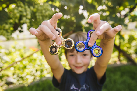 Happy boy with two spinnersの写真素材