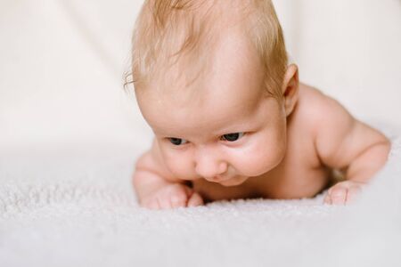 The two-month boy trying to lift his head lying on his stomachの写真素材