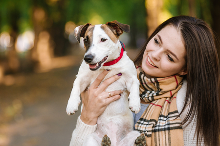 beautiful girl playing with a dog. Playing with the dog on the park. Close-up portrait. Jack Russell Terrierの写真素材