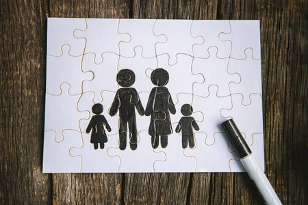 Family concept, puzzle. Father, mother, son and daughter painted on a puzzleの写真素材