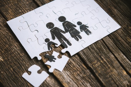 Family concept, puzzle. Father, mother, son and daughter painted on a puzzleの写真素材