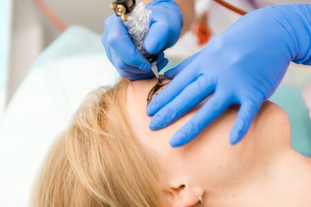 Beautiful woman with smooth, young skin, sitting in a beautician. A beautician performs modeling...