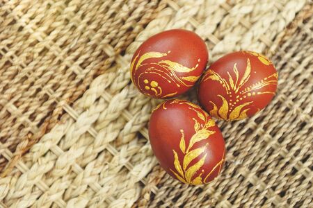 Three easter eggs in basket on a background of flowersの写真素材