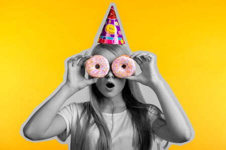girl on a yellow background with donutsの写真素材