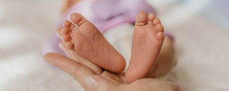 Baby legs. Legs newborn in parents handの写真素材