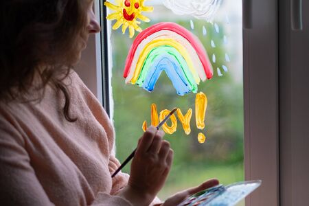 woman writes the word joy on the windowの写真素材