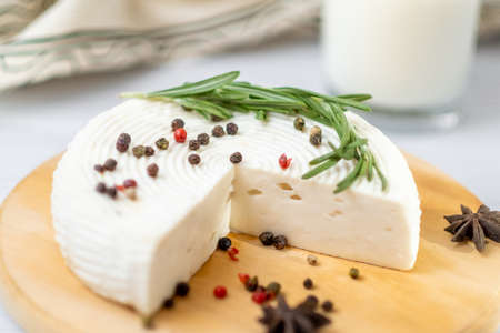 Homemade Adyghe cheese on a plate with spicesの写真素材