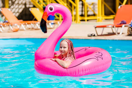 Girl swims on an inflatable flamingo