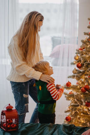 happy mother and cute little son decorating christmas tree togetherの写真素材