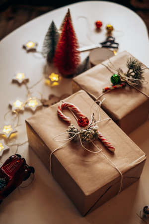 Christmas gifts lie on the table in festive packaging. Preparing and decorating the boxの写真素材