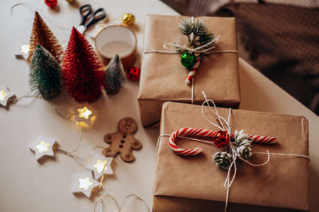 Christmas gifts lie on the table in festive packaging. Preparing and decorating the box