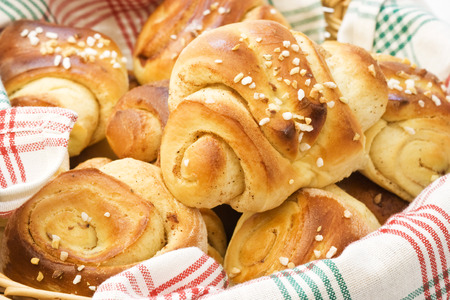 Homemade cinnamon buns in a basket with red and green tableclothの写真素材