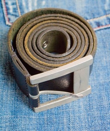 black rolled belt on jeans backgroundの写真素材