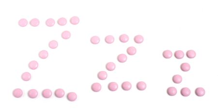 pink round somnifacient pills on whiteの写真素材