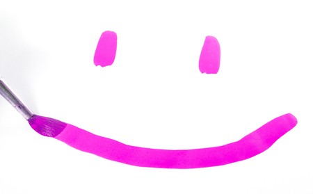 hand with brush painting pink smileの写真素材