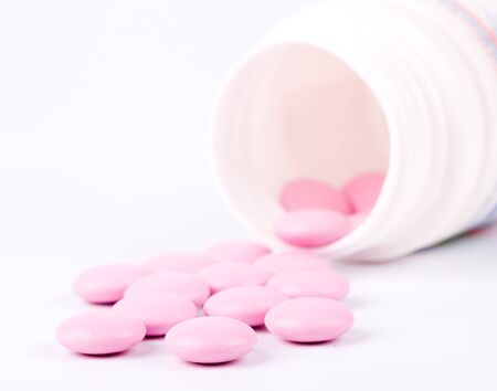 pink round pills in container
