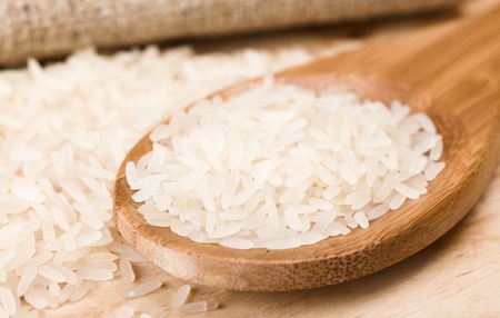 wooden spoon with raw riceの写真素材