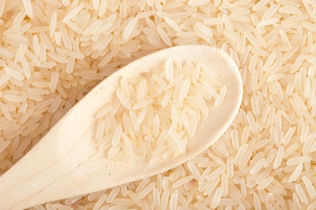 wooden spoon with raw riceの写真素材