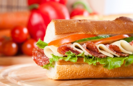 big sandwich with fresh vegetables on wooden boardの写真素材