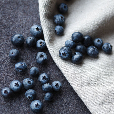 Blueberries, grey felt and linen as backgroundの写真素材