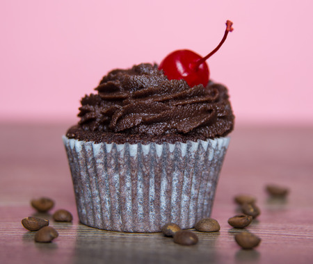 Chocolate cupcake with cream and cherryの写真素材
