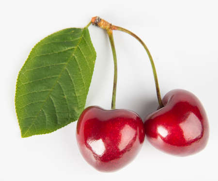 Three cherries with the leaf isolated on a whiteの写真素材