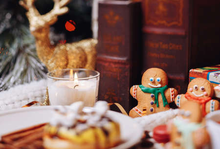 colorful Christmas sweets and hot drinks on the holiday table near the Christmas treeの写真素材