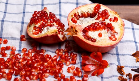 broken ripe pomegranate on a plaide fabricの写真素材