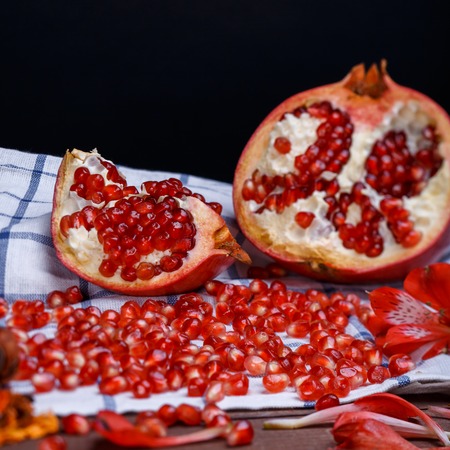 broken ripe pomegranate on a plaide fabricの写真素材