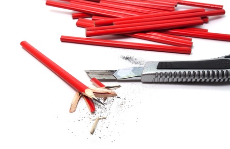 bunch of red construction pencils and office knife on a white backgroundの写真素材