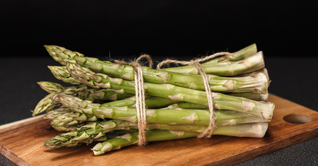 Bunch of green asparagus on black backgroundの写真素材