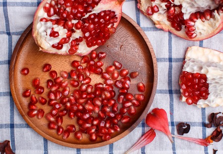 broken ripe pomegranate on a plaide fabricの写真素材