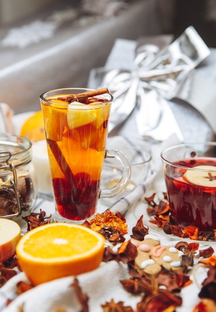 cup of hot mulled wine and a delicious cup of grog among the many delicious detail  on white checkered tableclothの写真素材