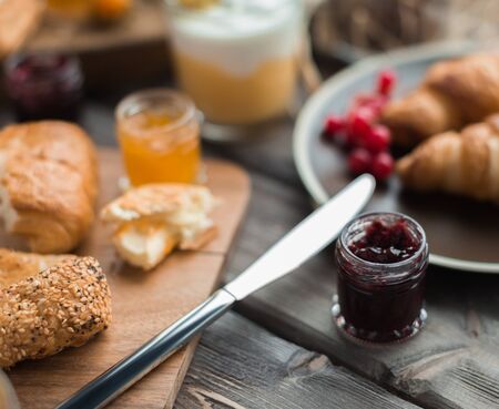 berry jam in the little jar (for buns) for breakfast on a wooden tableの写真素材