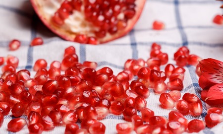 broken ripe pomegranate on a plaide fabricの写真素材