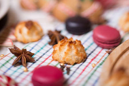 colorful Christmas sweets and hot drinks on the holiday table near the Christmas treeの写真素材