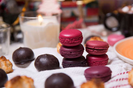 colorful Christmas sweets and hot drinks on the holiday table near the Christmas treeの写真素材