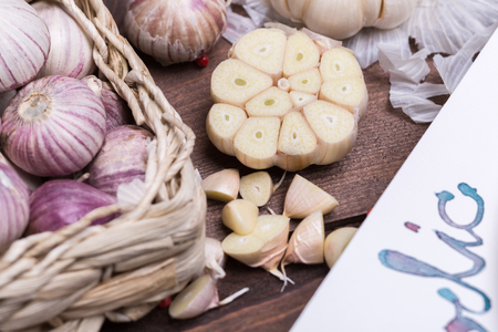 garlic, red pepper and ginger on a wooden table with utensils, cloth and cutting boardの写真素材