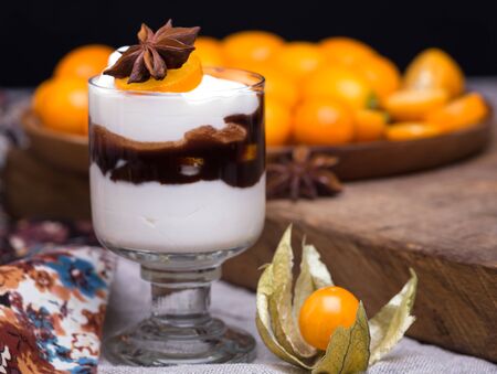 cream and chocolate dessert and berry of physalis and heap of kumquat on a different fabricの写真素材