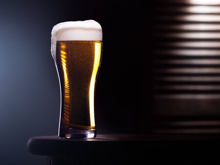 Glass of light beer on wooden table with wooden backgroundの写真素材