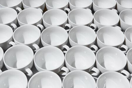 Top view on many stacked in rows of empty clean white cups for tea or coffee. Close-up. Background.の写真素材