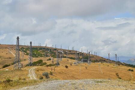 Wind turbine power plants for generating clean energy from wind power. Wind farm on mountain against...