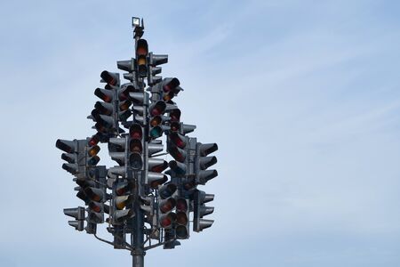 Art installation of many traffic lights located on single pole against blue sky. Space for text.の写真素材