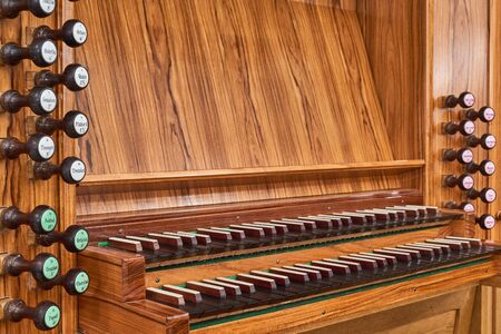 Element of organ instrument, pulls, wooden keyboard console and control panel, close up.の写真素材