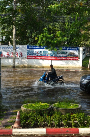BANGKOK - NOVEMBER 7: Motorcycle navigating through the flood after the heaviest monsoon rain in 20 years in the capital  on November 7, 2011  Nuan Chan Road, bangkok, Thailand.のeditorial素材