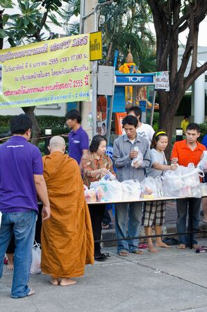 BANGKOK, THAILAND - JANUARY 8:Unidentified Bangkok people give food offerings for monks in new year day festival on Jan 8, 2012 at Baan Suan Thon village,Bangkok , Thailandのeditorial素材