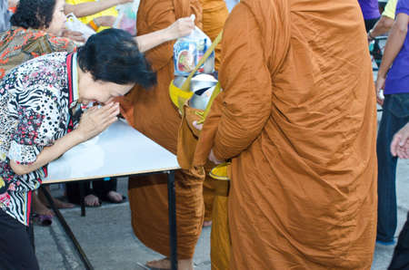 BANGKOK, THAILAND - JANUARY 8:Unidentified Bangkok people give food offerings for monks in new year day festival on Jan 8, 2012 at Baan Suan Thon village,Bangkok , Thailandのeditorial素材