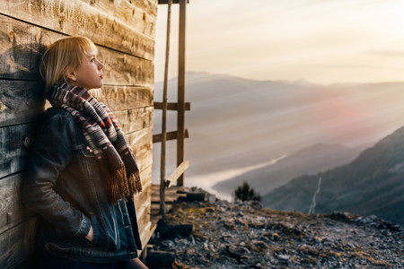 Beautiful girl watching sunset at mountain topの写真素材